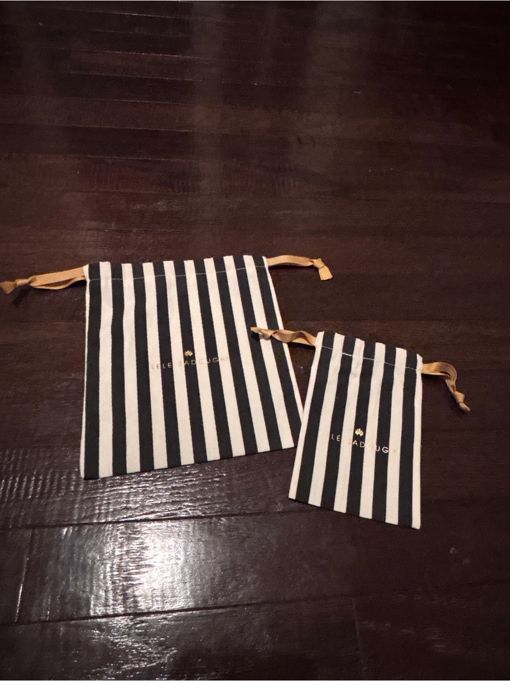 Lele Sadoughi Black and White Striped Drawstring Pouches with Gold Logo